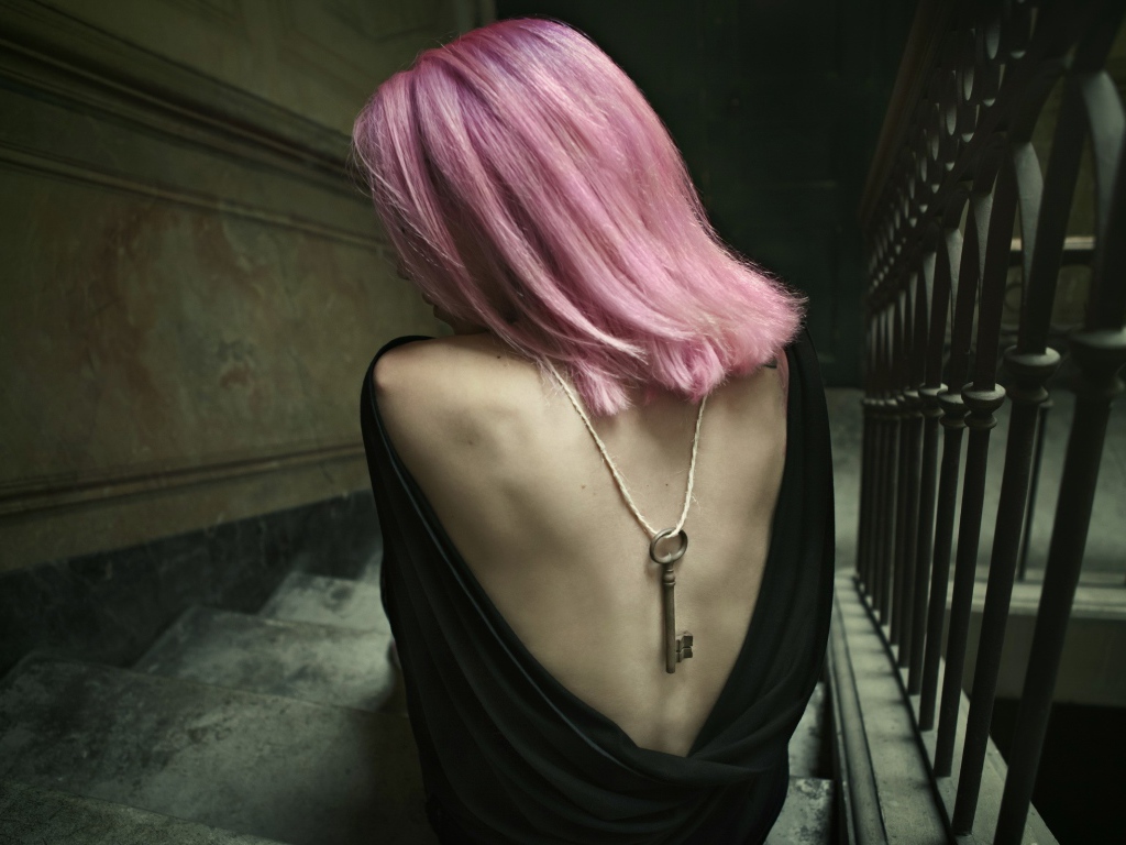 Девушка с розовыми волосами сидит на лестнице