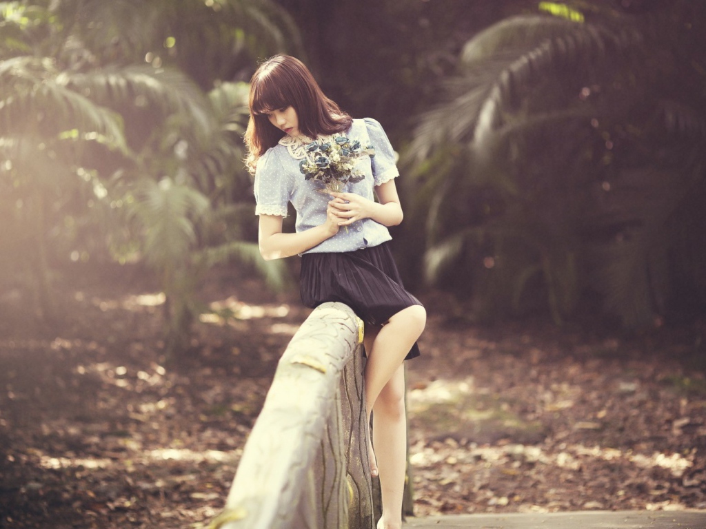 Азиатка с букетом на поручне моста