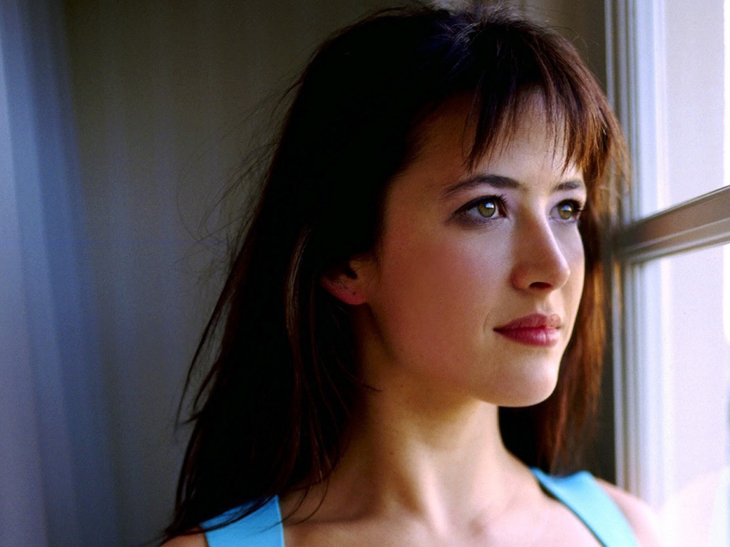 Красивая девушка смотрит в окно