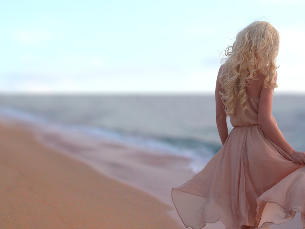 Блондинка в легком платье на пляже