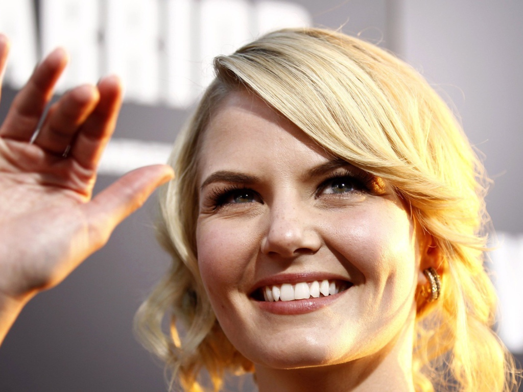 Блондинка улыбается и машет