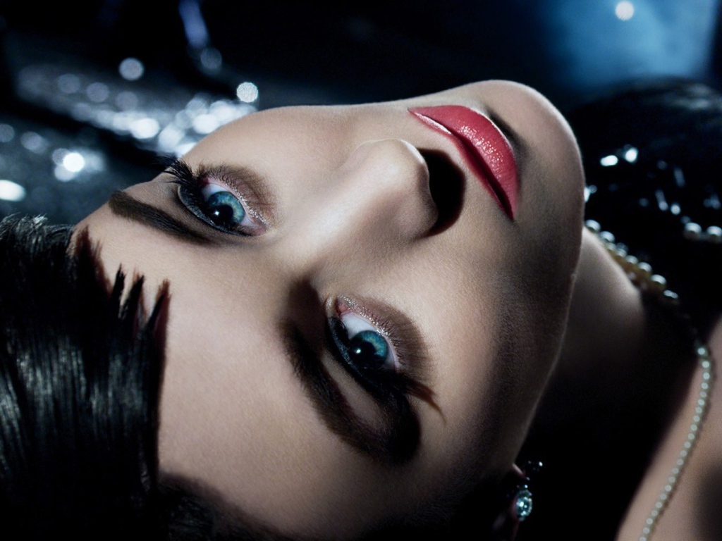 Голубоглазая брюнетка лежит в черном платье