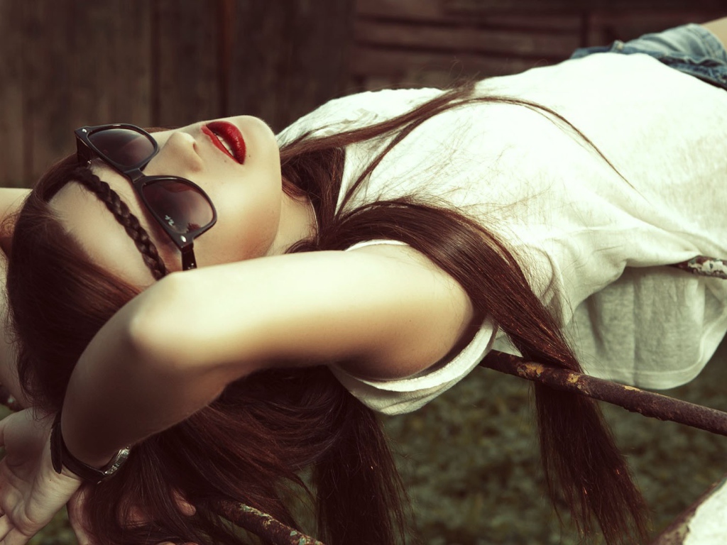 Брюнетка в темных очках смотрит в небо