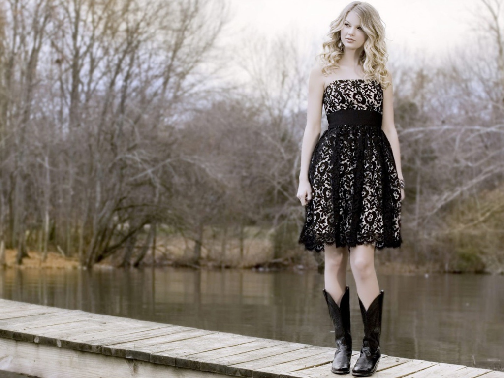 Девушка в черном платье и кожаных сапогах