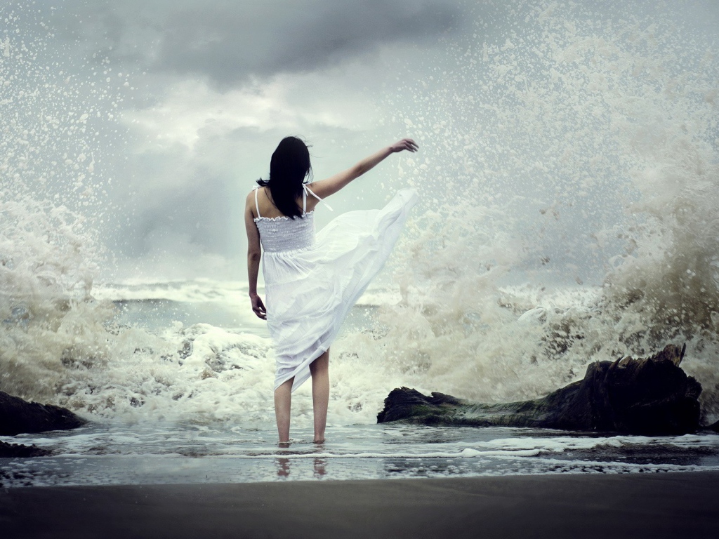 Девушка в белом платье среди брызг прибоя