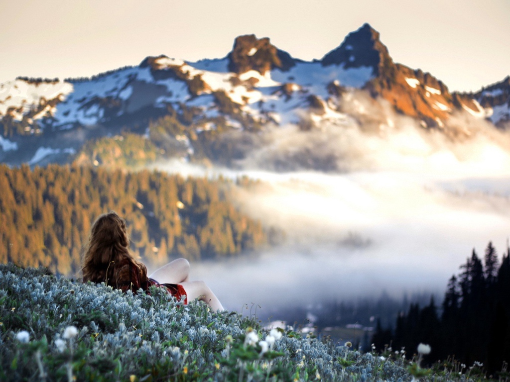 Девушка лежит и смотрит на горы
