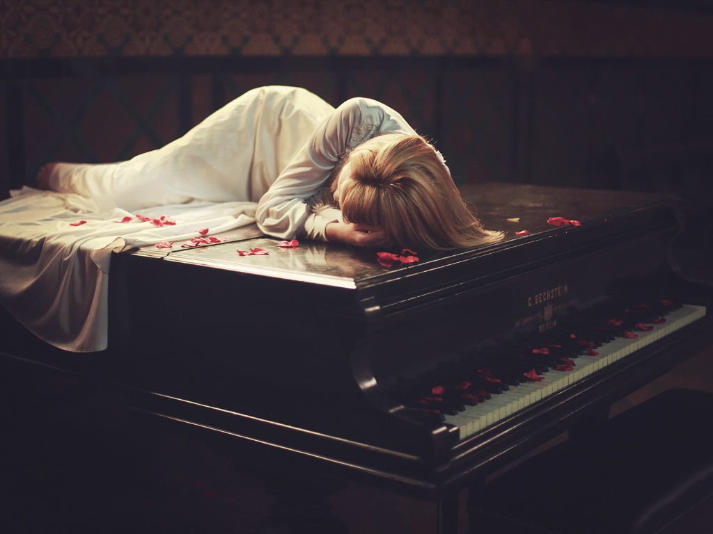 Девушка лежит на рояле