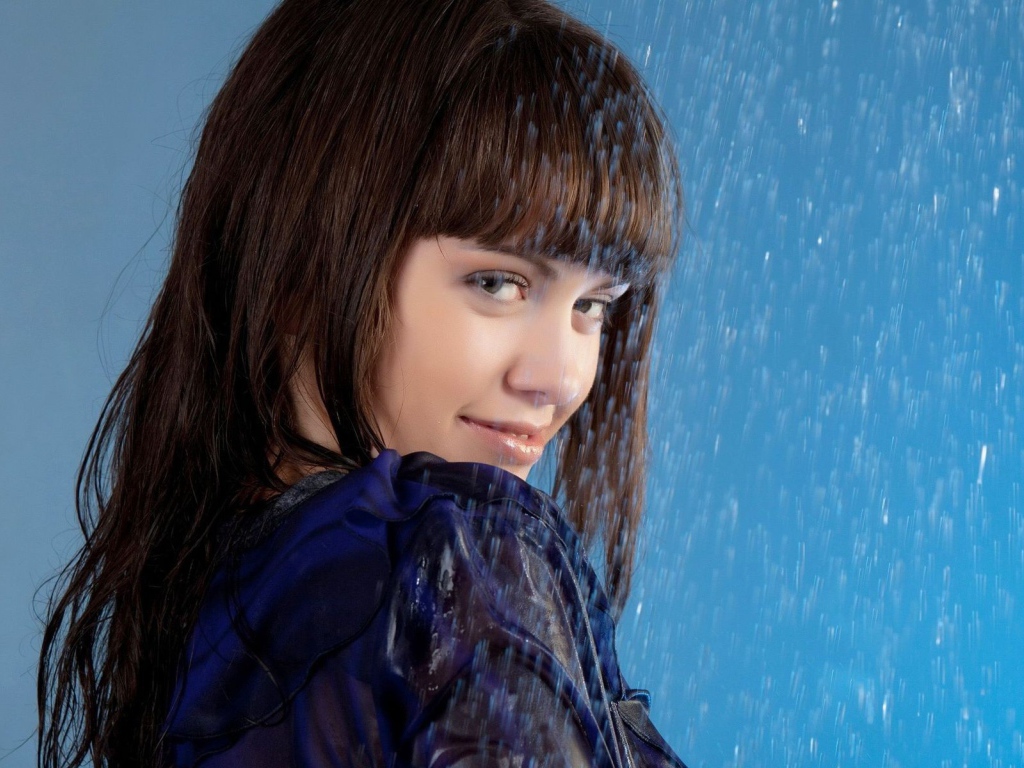 Девушка стоит под струей воды