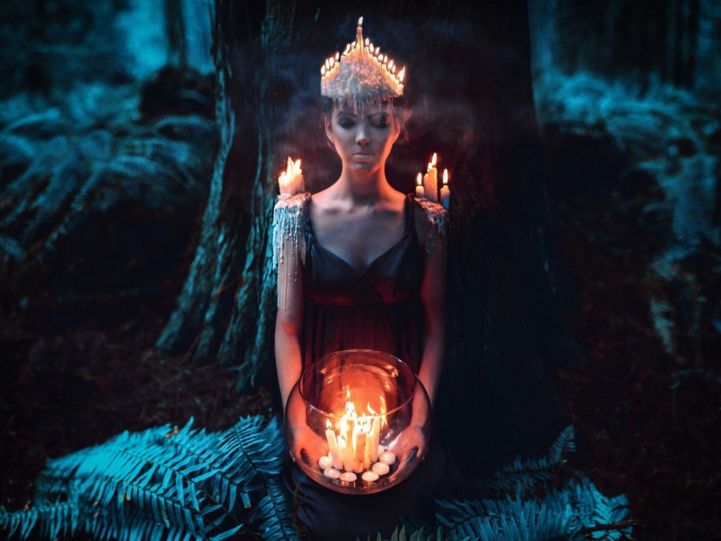 Девушка в окружении свечей в лесу