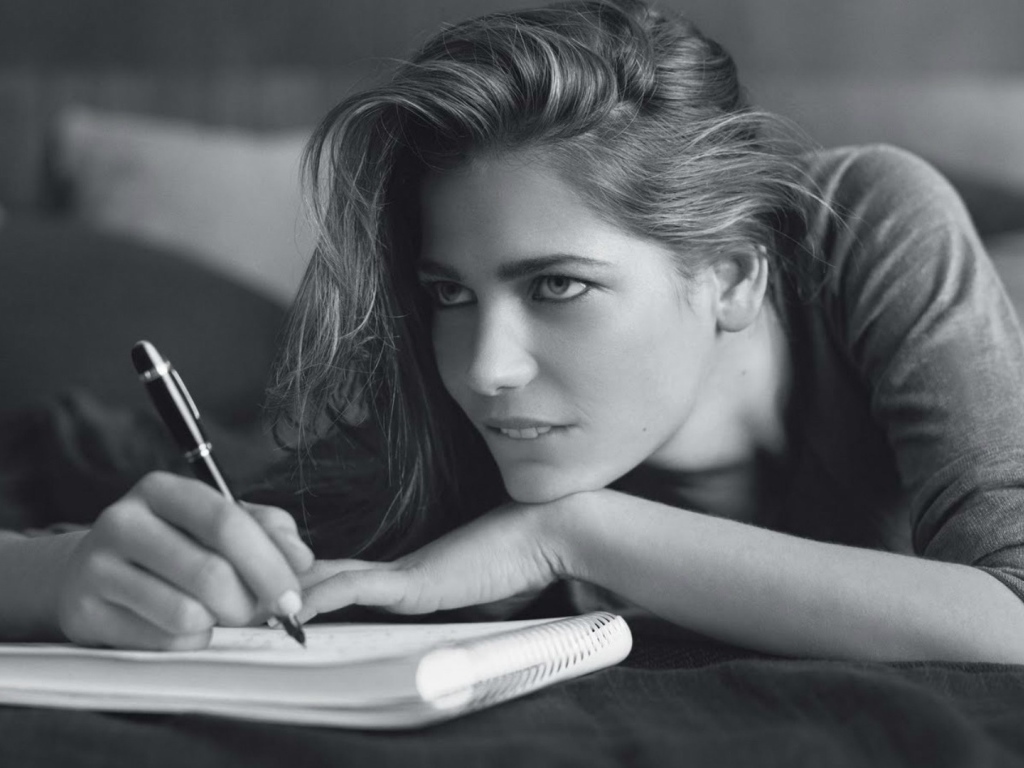 Девушка пишет в блокноте