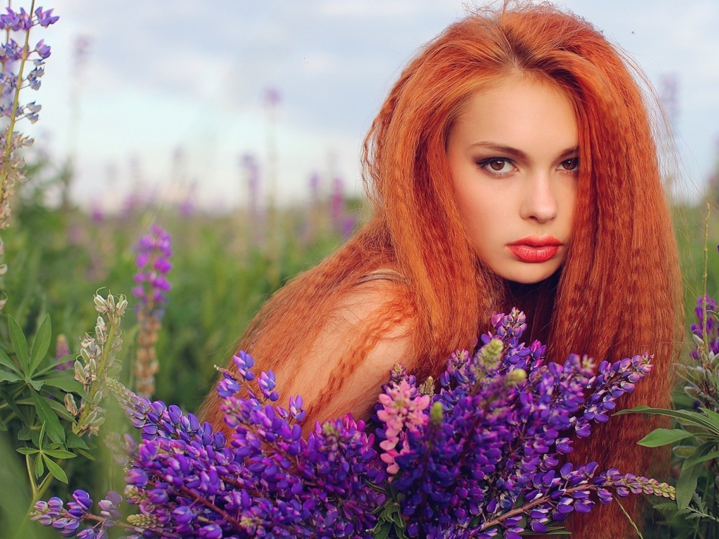Длинноволосая рыжая девушка в поле лаванды