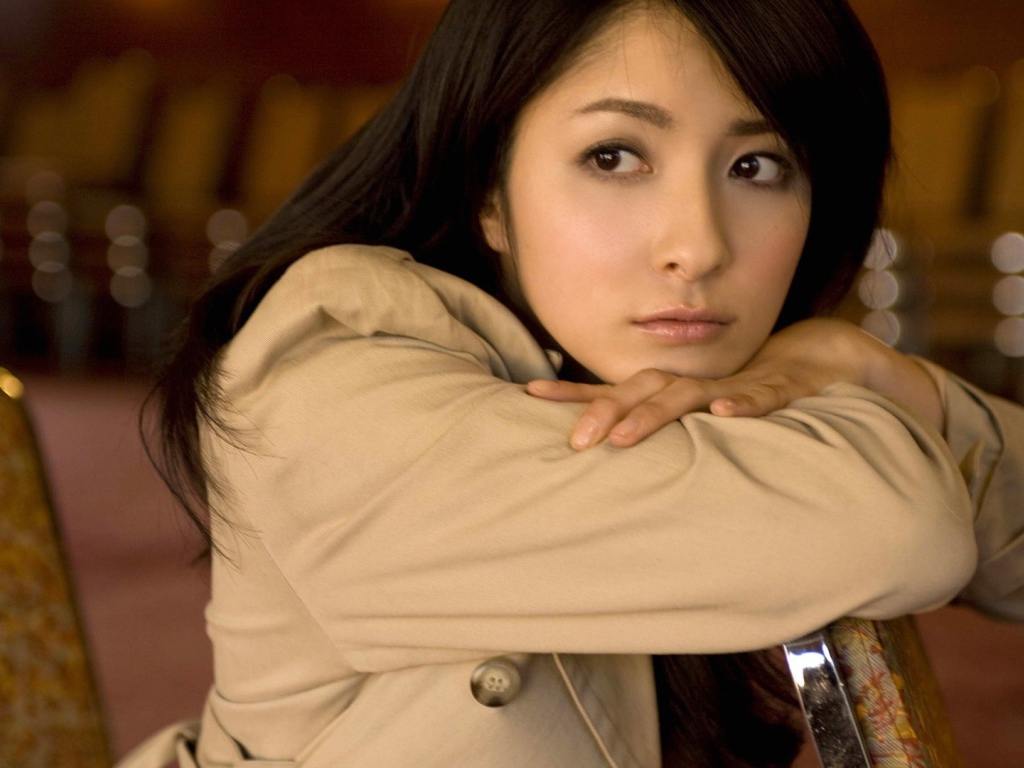 Грустная азиатская девушка в коричневом плаще