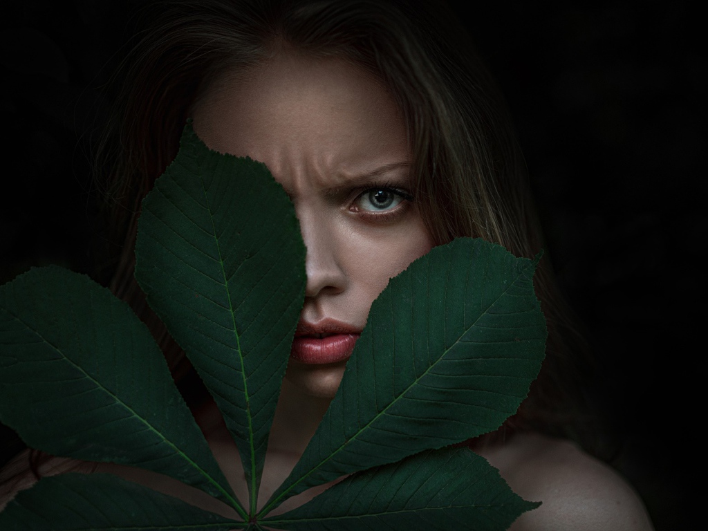 Девушка прикрыла лицо листьями каштана