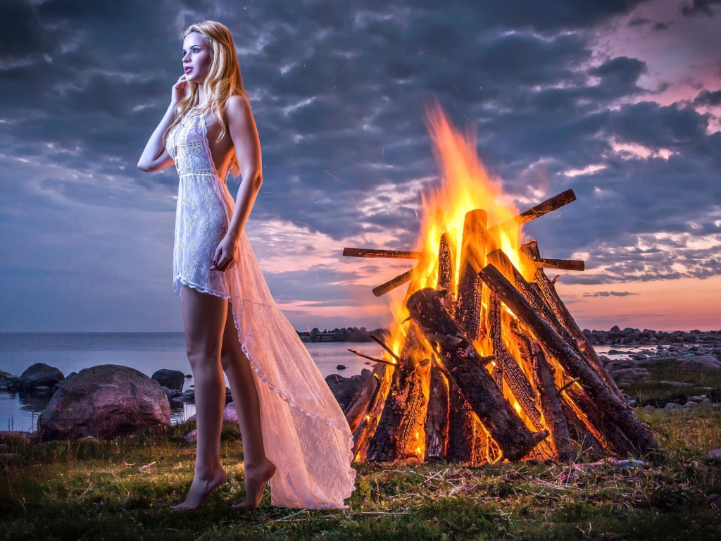 Девушка у костра на берегу океана