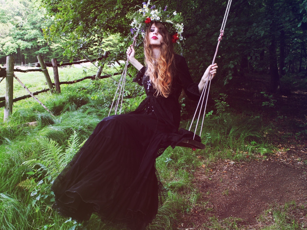 Девушка в черном платье на качели