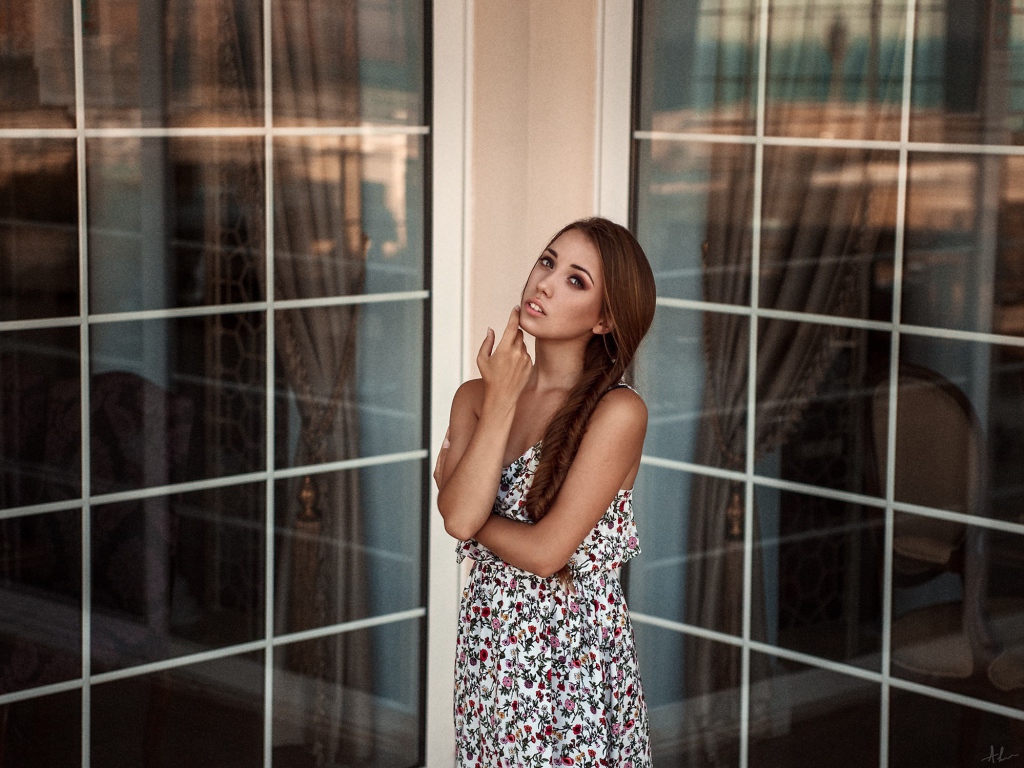 Девушка в углу между окнами