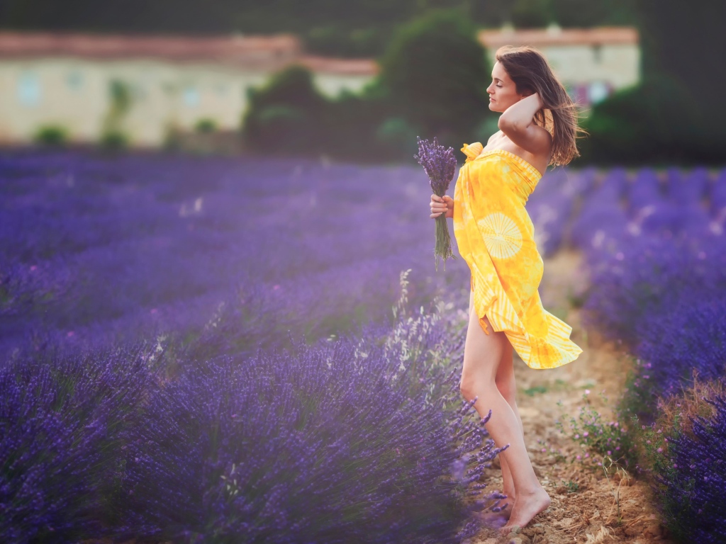 The girl in yellow pareo with a bouquet of lavender on field