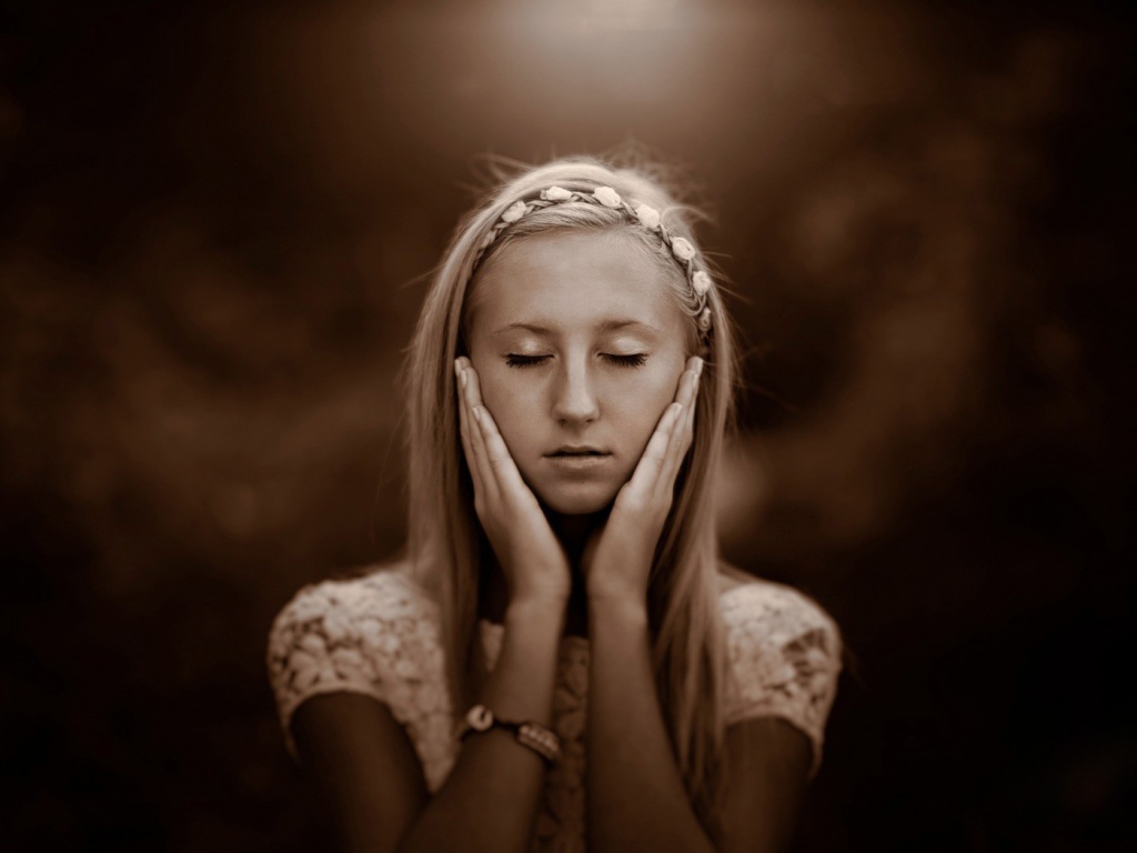 Девушка прикоснулась руками к лицу