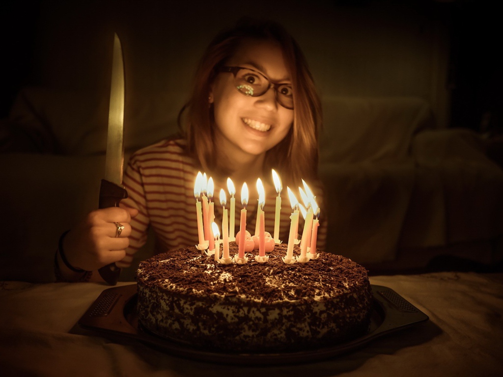 Девушка с ножом у праздничного торта