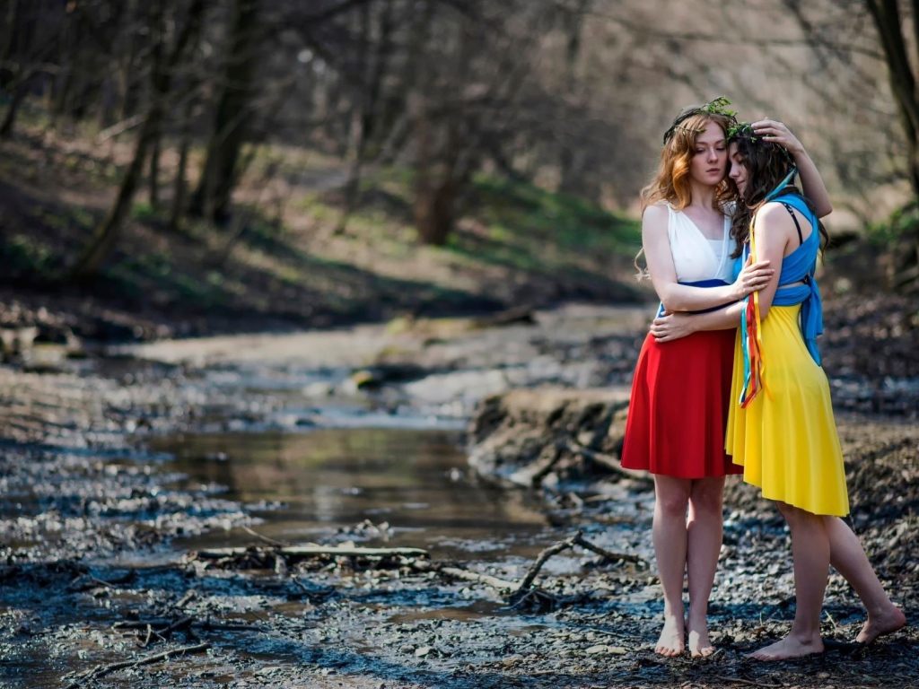 Две девушки в ярких платьях в чаще леса