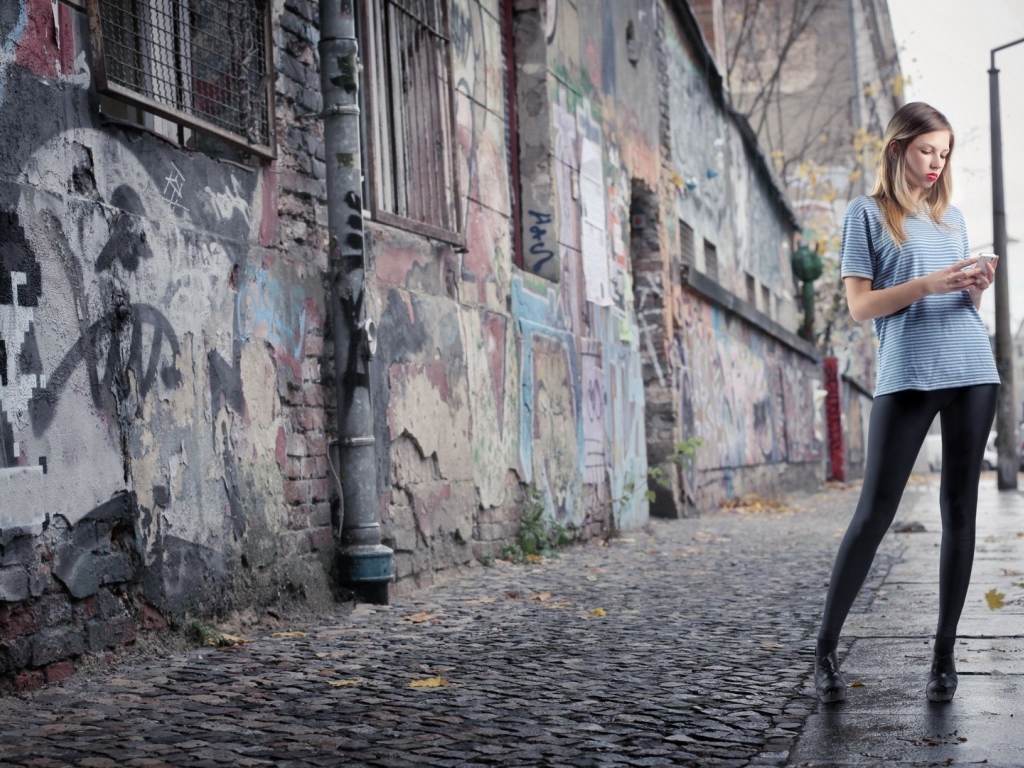 Молодая девушка стоит на улице в трущобах