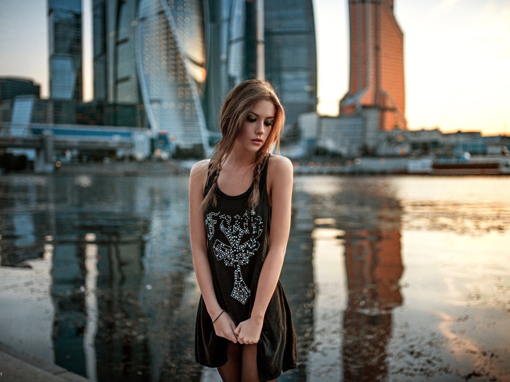 Модель на фоне реки и небоскребов