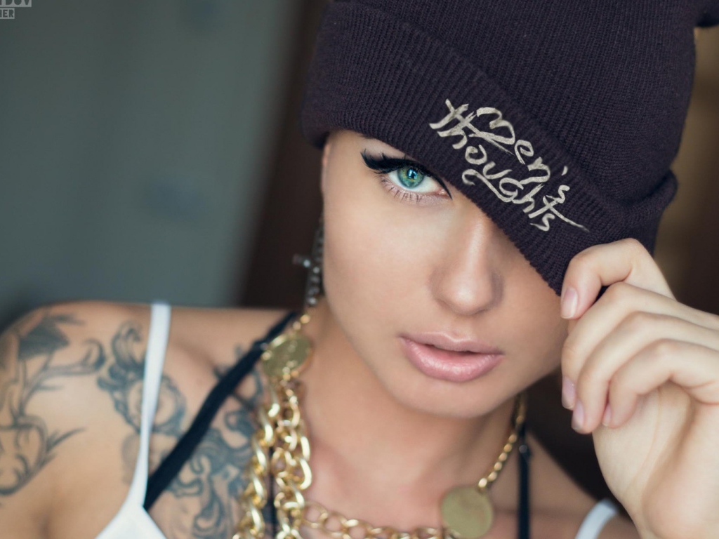 Модель с татуировками и золотой цепью на шее