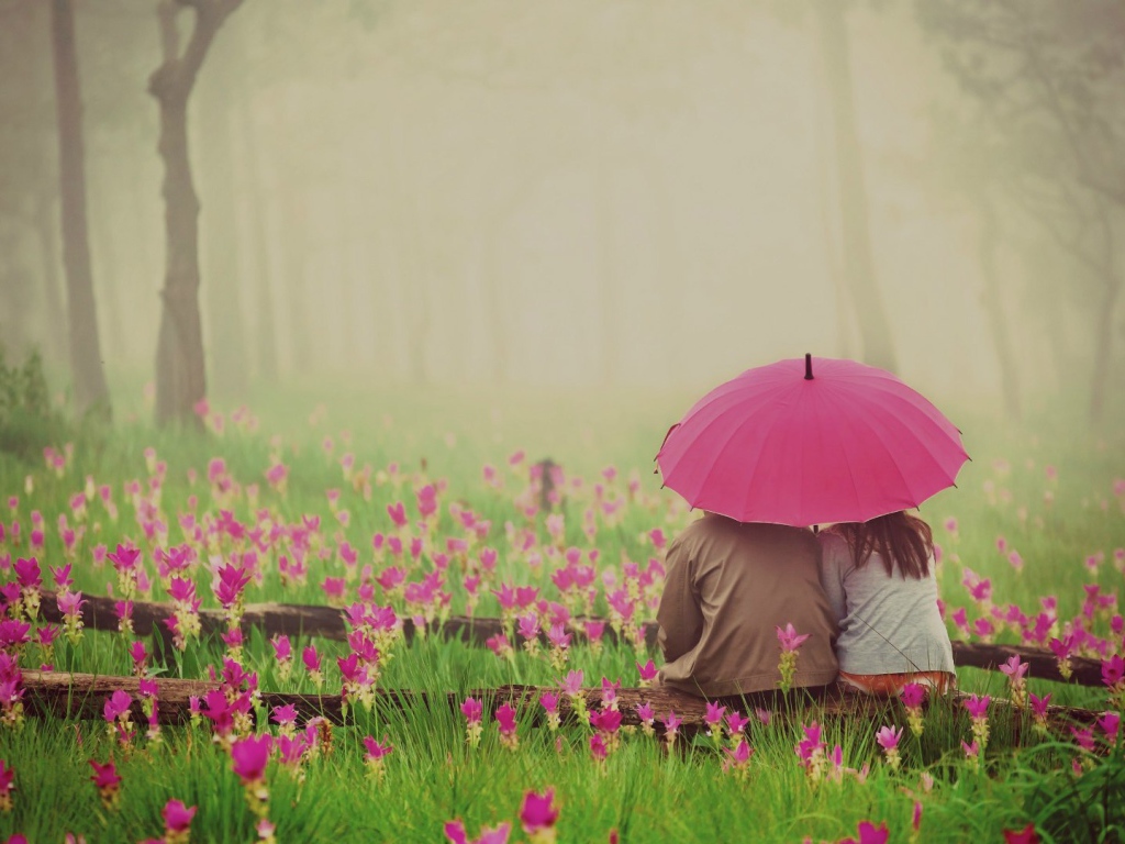 Двое сидят под зонтом