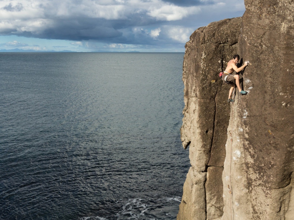 Мужчина скалолаз на скале над морем