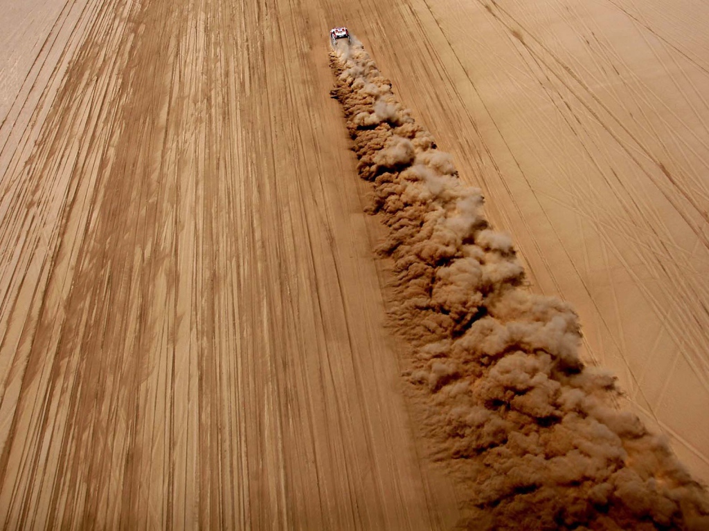 Облако пыли за автомобилем в пустыне