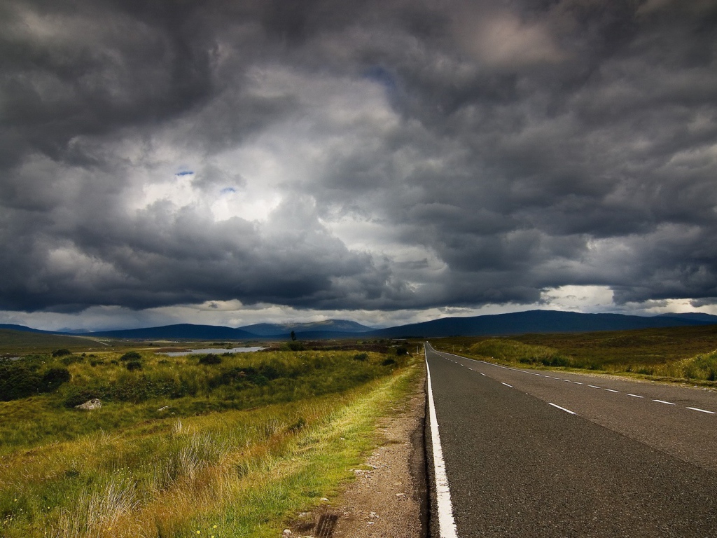 Шоссе среди полей под мрачными облаками
