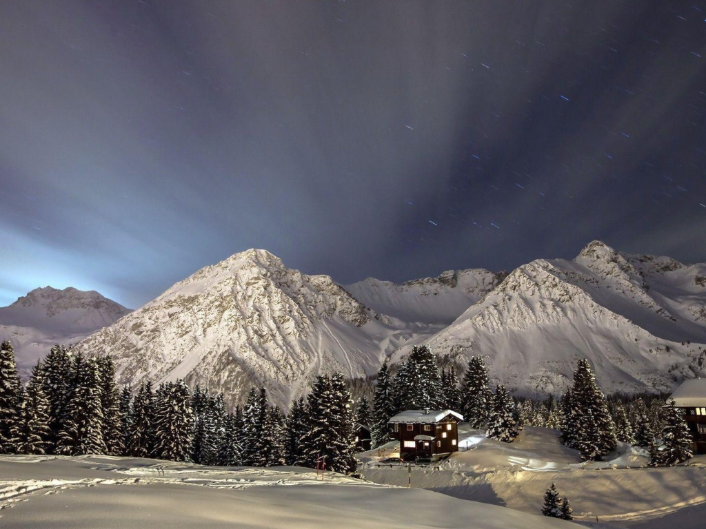 Лучи света над заснеженными горами