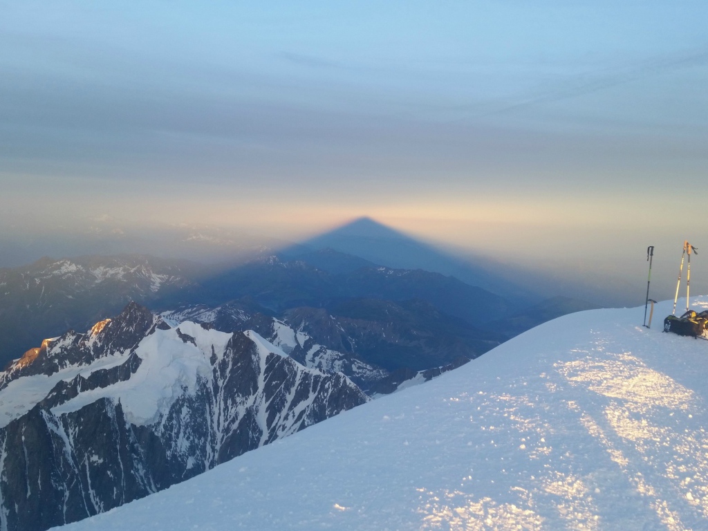 Лыжники на вершине горы перед закатом солнца