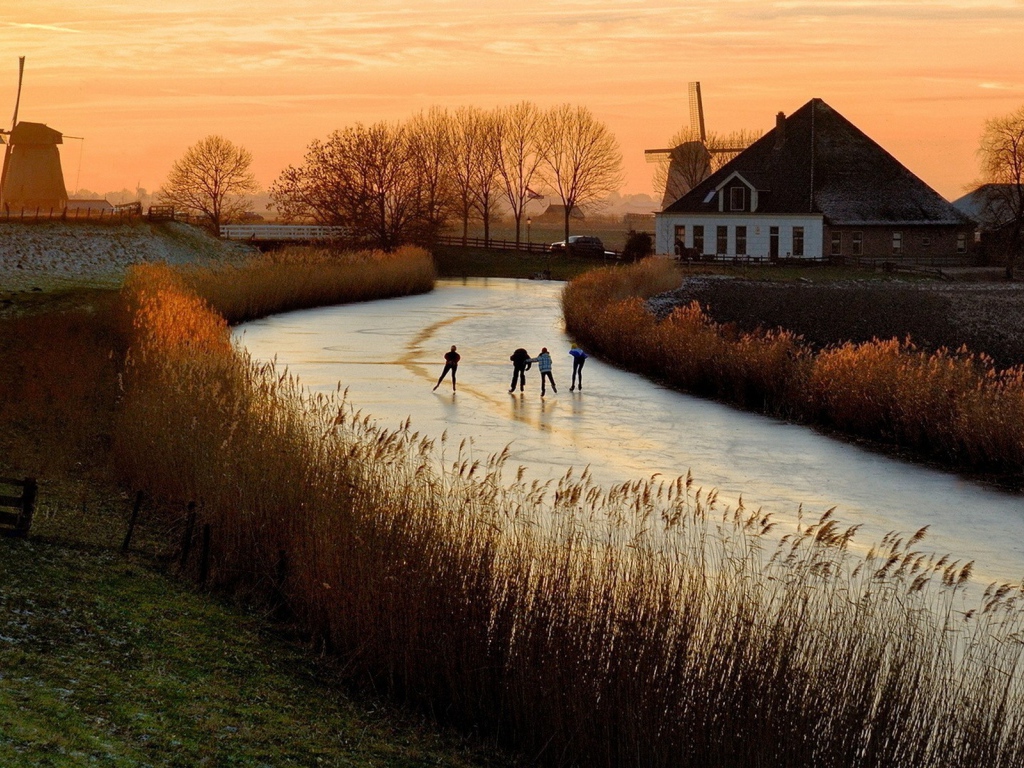 Дети катаются на коньках по замерзшей реке в Нидерландах