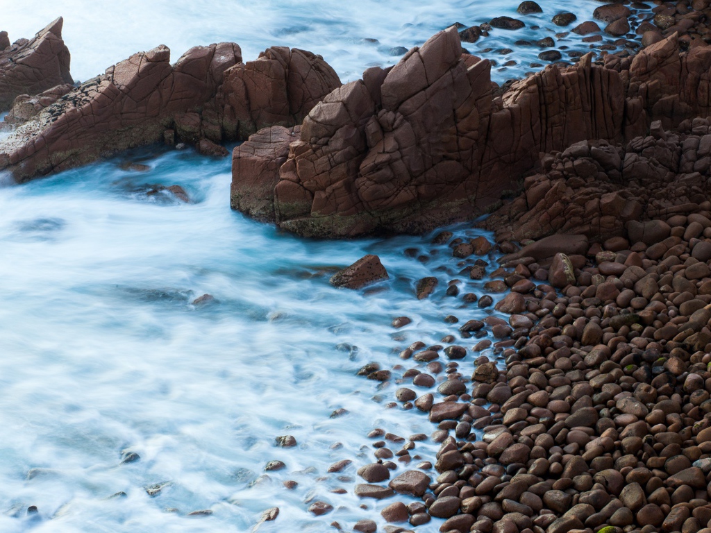 Мелкие коричневые камни на берегу моря