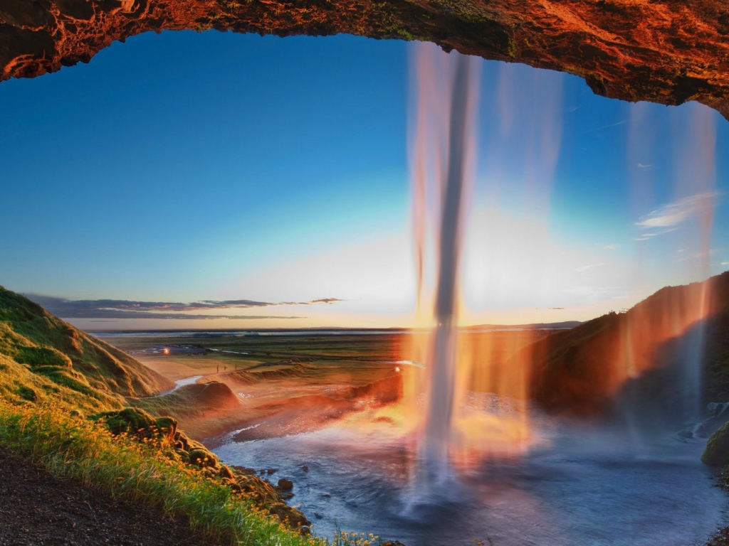 Поток воды падает с желтой скалы