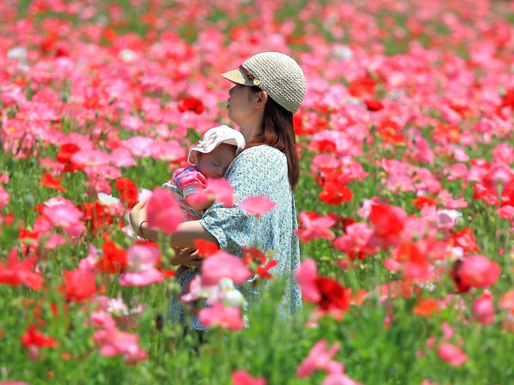Девушка с ребенком идет по полю цветов