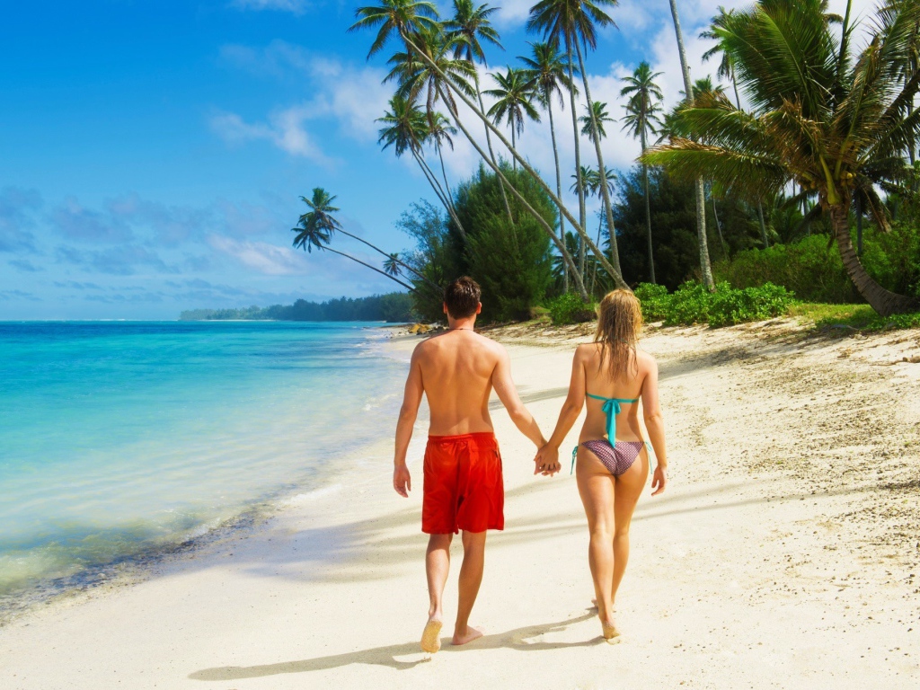 Парень и девушка идут по пляжу