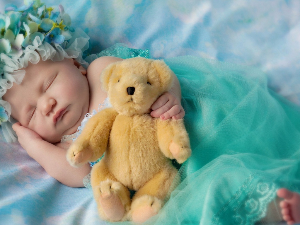 Ребенок спит с медвежонком в руке