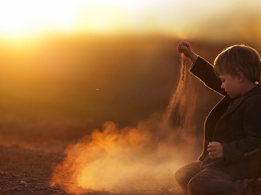 Мальчик играет песком