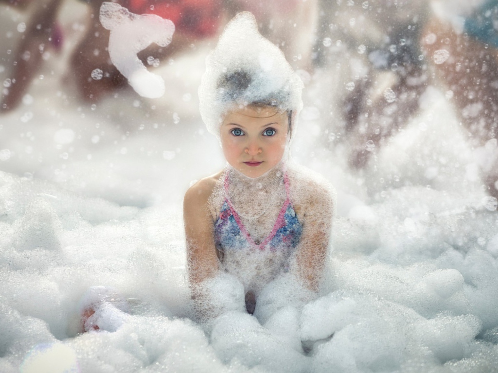 Девочка играет в пене