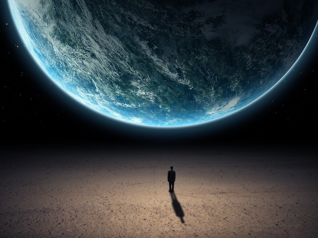 Человек стоит перед планетой