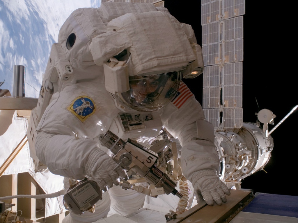 Космонавт на орбите выполняет ремонт