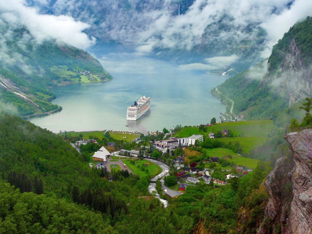 Круизный корабль у прибрежной деревушки в Норвегии