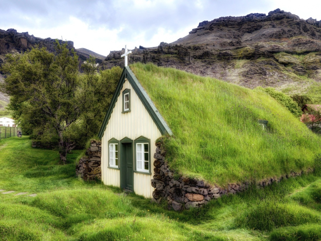 Поросшая травой крыша церкви в горной деревушке