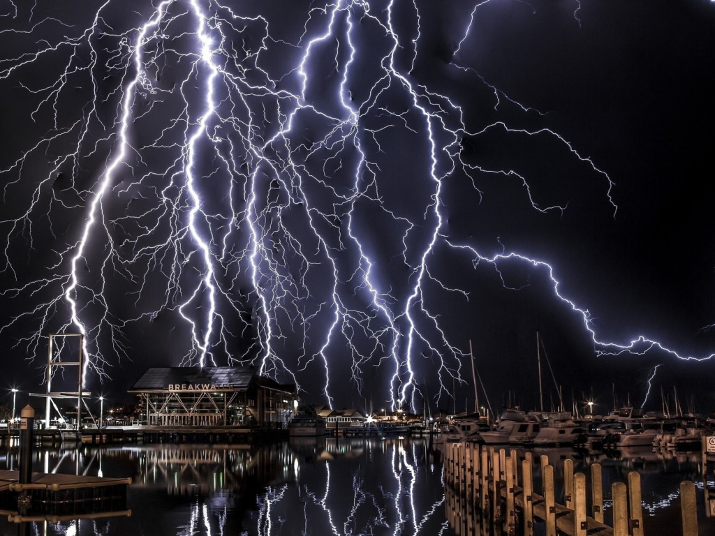 Молнии в черном небе над портом