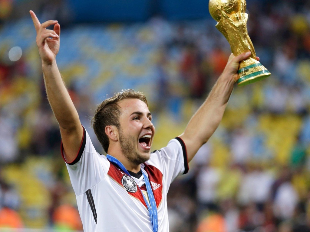 Немецкий футболист Марио Гётце держит в руке кубок