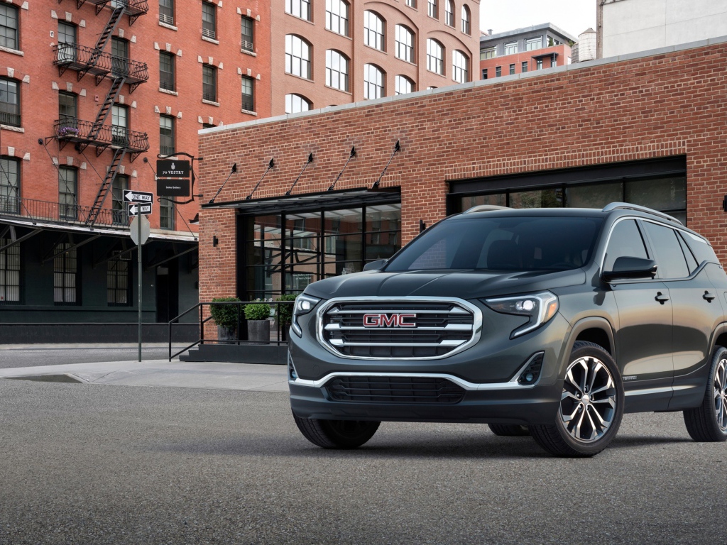 Серый внедорожник GMC Terrain на фоне здания