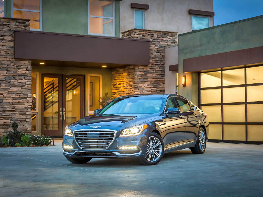 Серебристый автомобиль Genesis G80 с включенными фарами