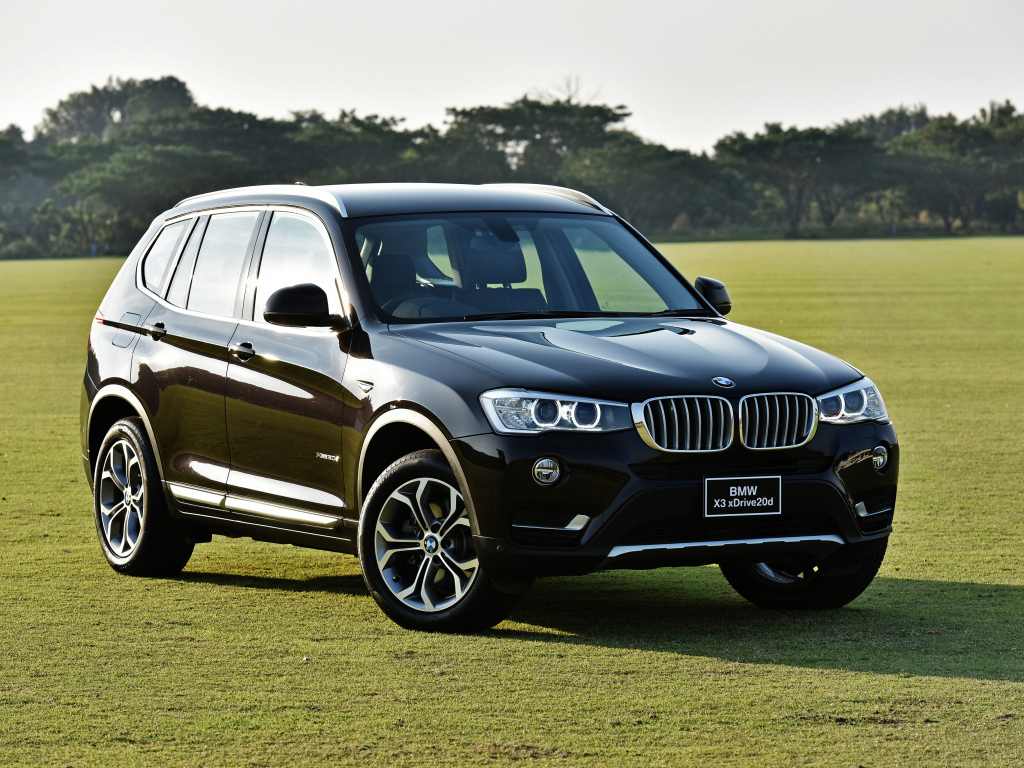 Черный автомобиль  BMW X3 на поле для гольфа 